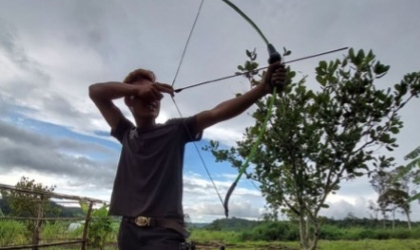 man practicing shooting arrows at archery shooting range