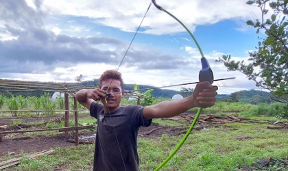 man aiming his bow at target